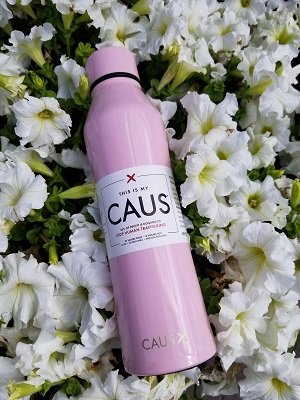 CAUS pink bottle in field of flowers